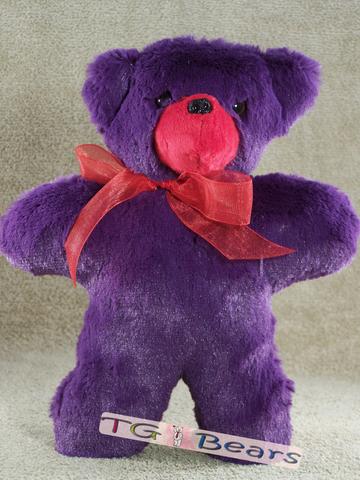 Small handmade teddy bear with purple fur and red accents